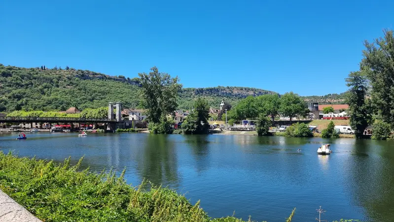 Cajarc vu de l'Aveyron avec la scène du festival Africajarc qui se monte au bord de l'eau