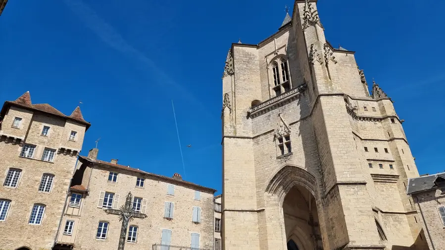un petit avion passe au dessus du donjon clocher de la Bastide de Villefrancehe de Rouerge