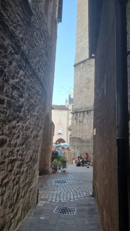 une fileuse et un musicien au pied de la collégiale de Villefranche de Rouergue