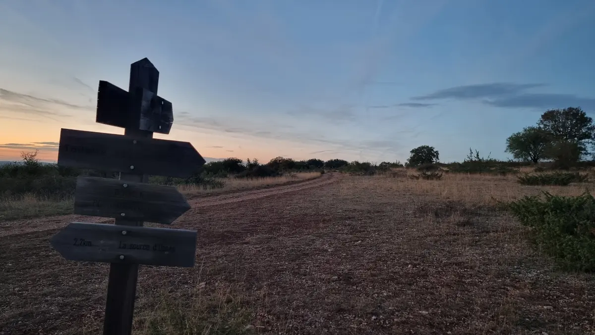 des flèches en bois peu lisibles sur un piquet désignent diverses directions sur la causse