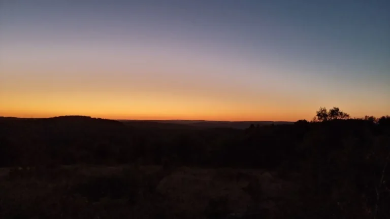 soleil au couchant sur le causse dans son orange sous le ciel bleuté de la nuit