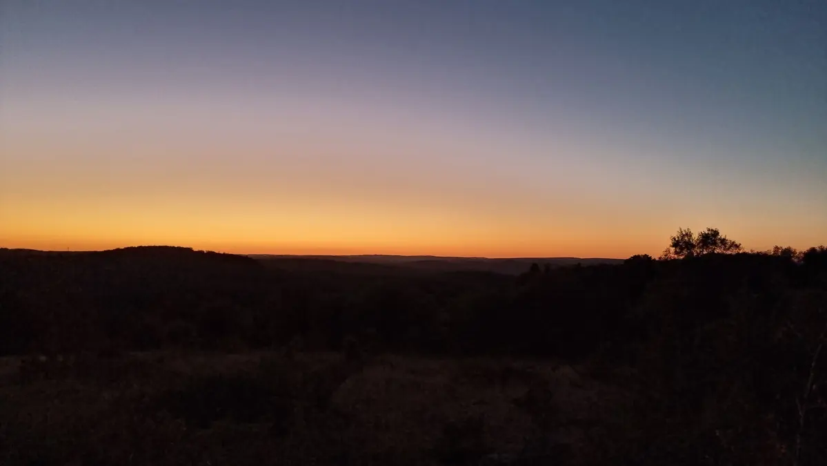 soleil au couchant sur le causse dans son orange sous le ciel bleuté de la nuit